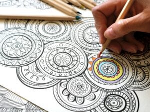 A coloring page filled with zentangles partially colored