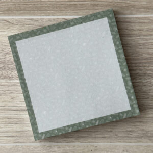 a square sticky notepad with an assortment of white leaves along the border with a soft green background