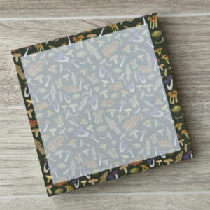 Pattern of an assortment of mushrooms on a dark green background on a square sticky note pad
