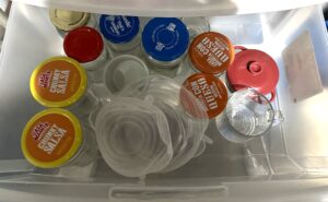 Assorted collection of jars from pickles, queso, salsa, etc in a plastic drawer.